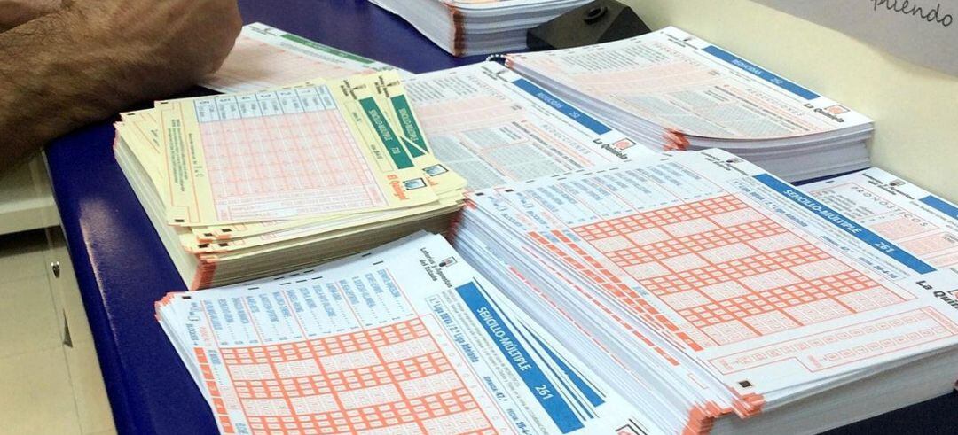 Una persona completa un boleto de lotería en una Administración.