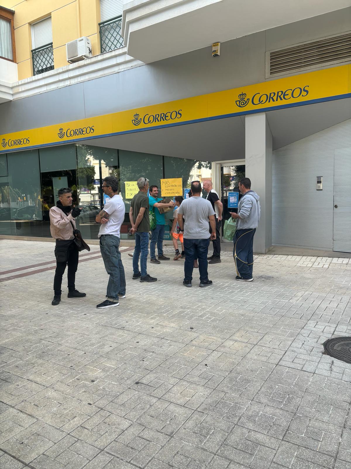 La trabajadora afectada, con sus representante sindicales, ante la oficina de Correos en Málaga