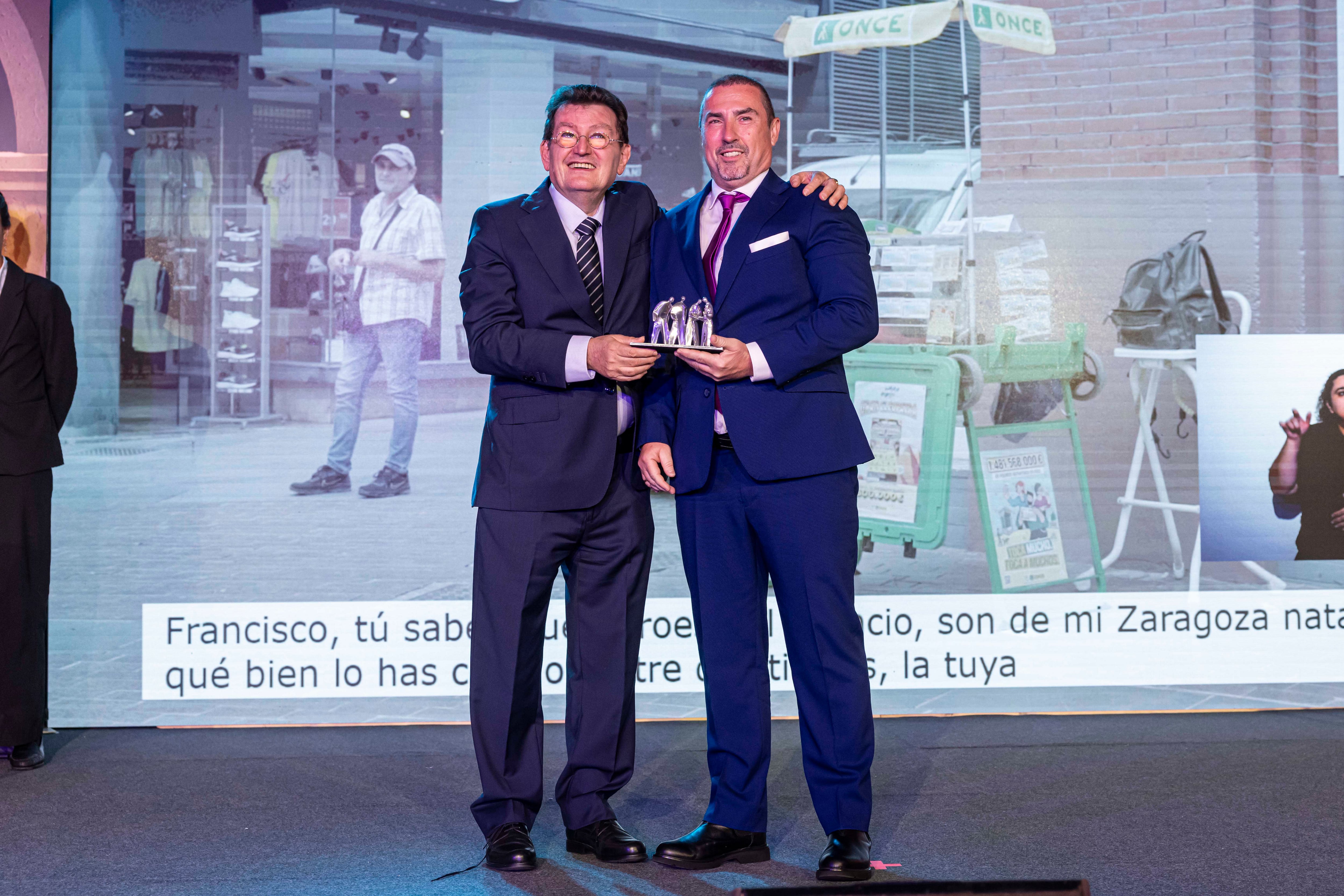 De izqda a dcha, el director general de la ONCE, Ángel Sánchez, entrega a Francisco Amaro el premio como mejor vendedor de 2023 en Granada, Jaén y Almería.