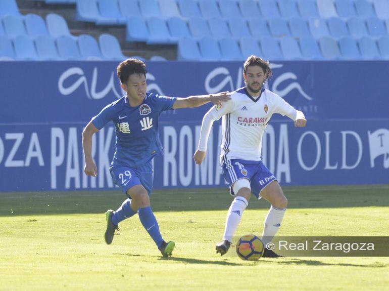 Oliver Buff controla un balón ante la presión de un futbolista rival