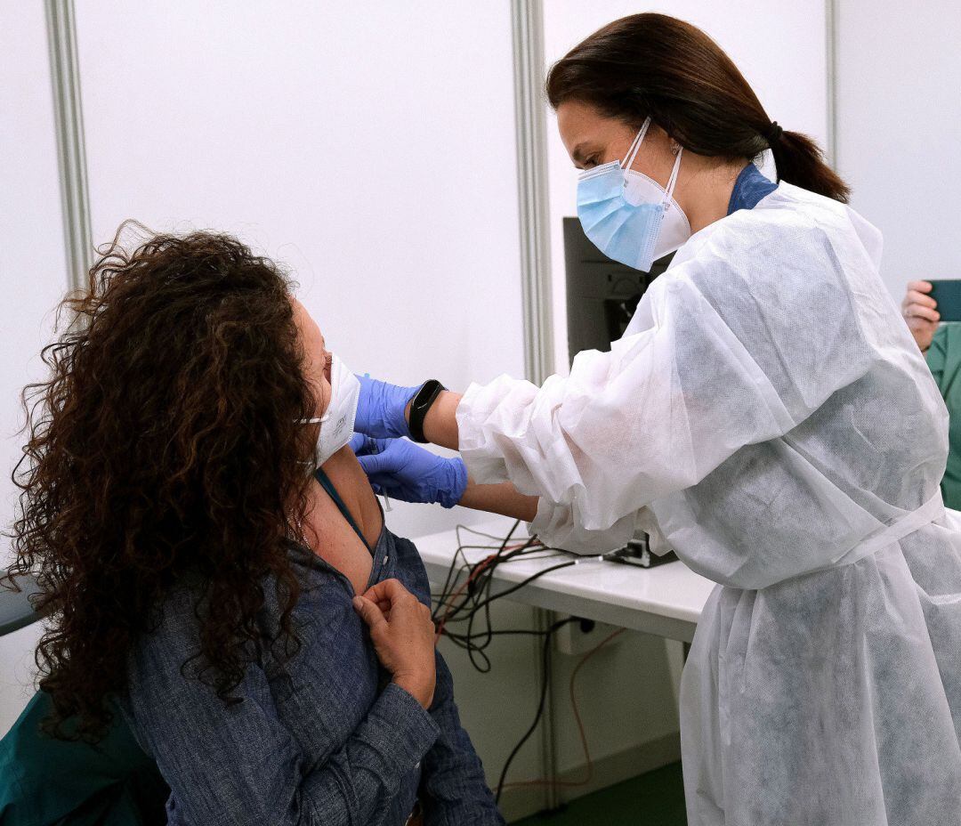 Una sanitaria suministra la vacuna contra la COVID-19