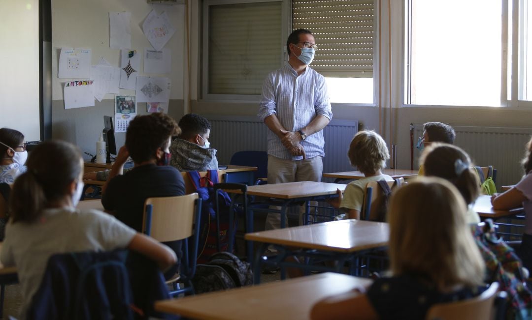 Un aula con escolares y un profesor.