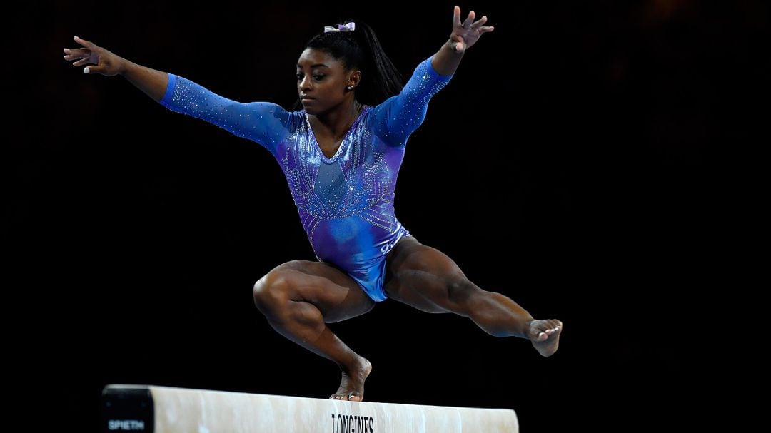 Simone Biles, en pleno ejercicio en barra fija