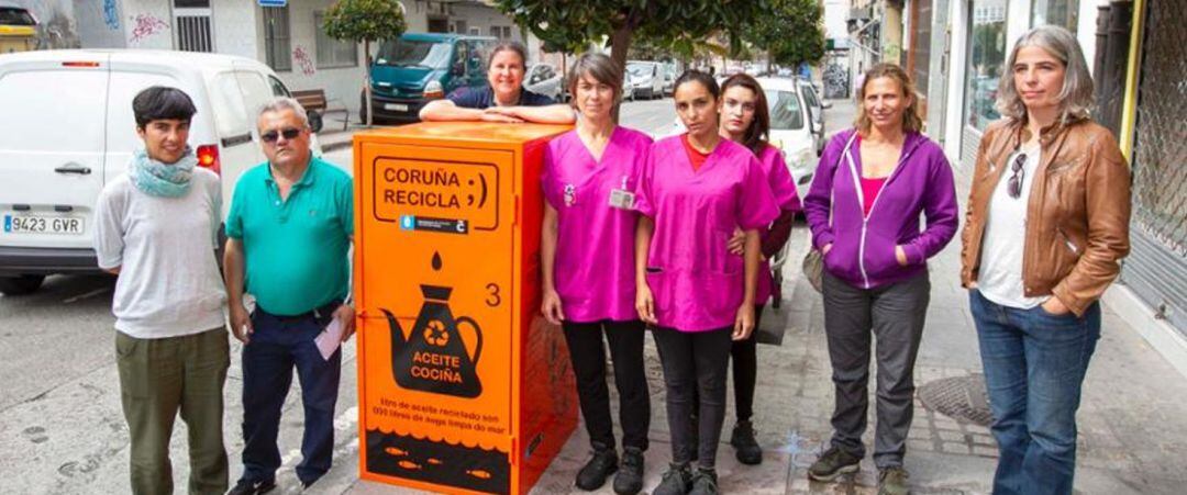 Las concejalas Claudia Delso y María García, con las trabajadoras de retirada de aceite y uno de los contenedores