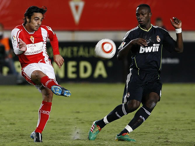 El jugador del Murcia Antonio Cañadas golpea la pelota frente al madridista Mahamadou Diarra en el partido de ida de los dieciséisavos de final de la Copa del Rey