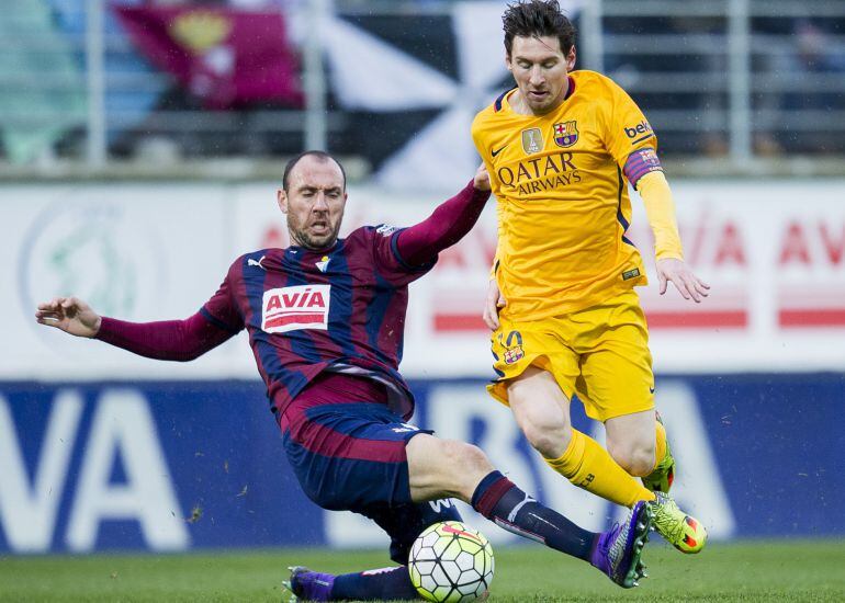 Ramis trata de robar un balón a Messi