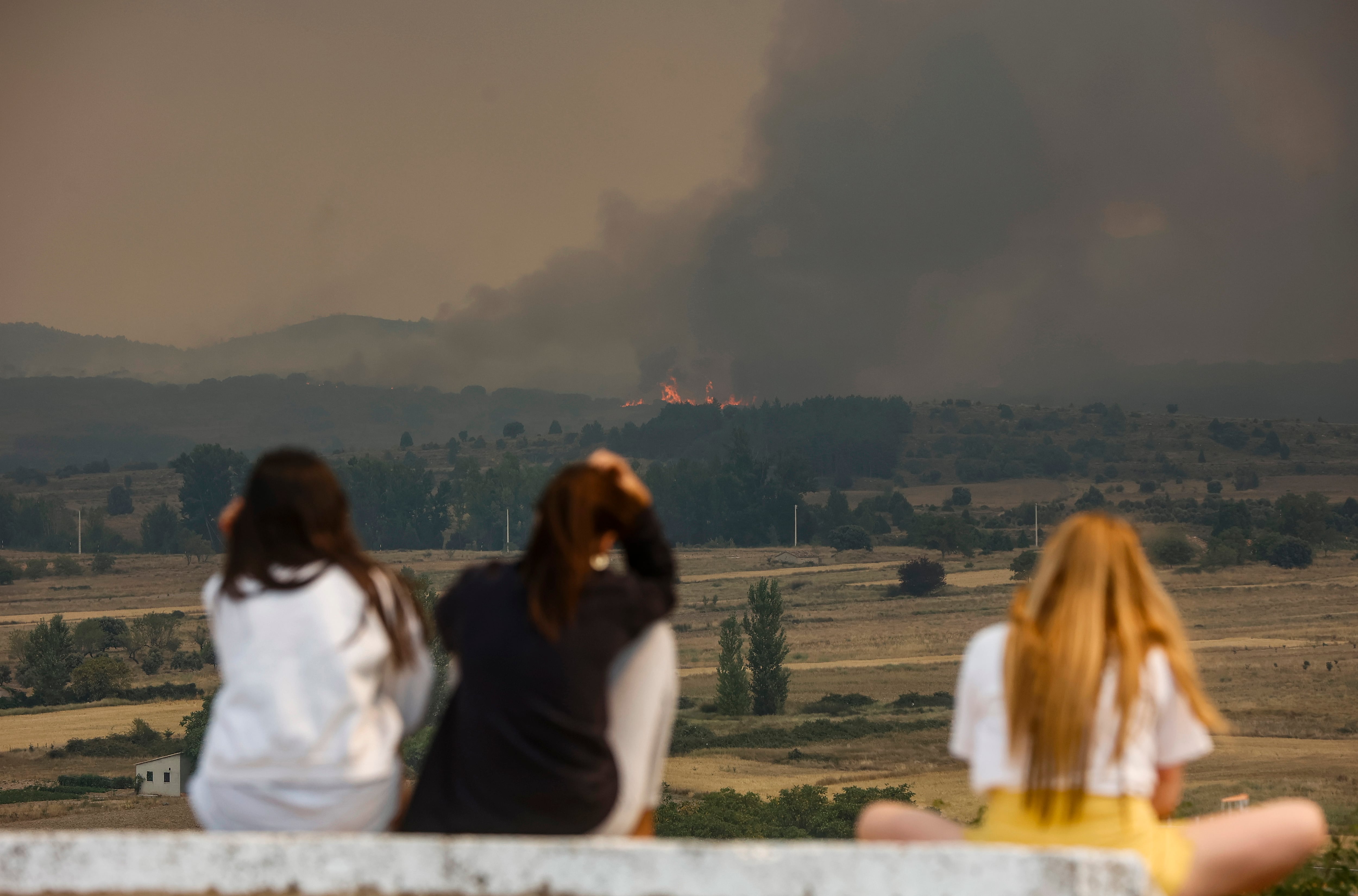 Varias ciudadanas observan el avance de las llamas en Bejís (EP).