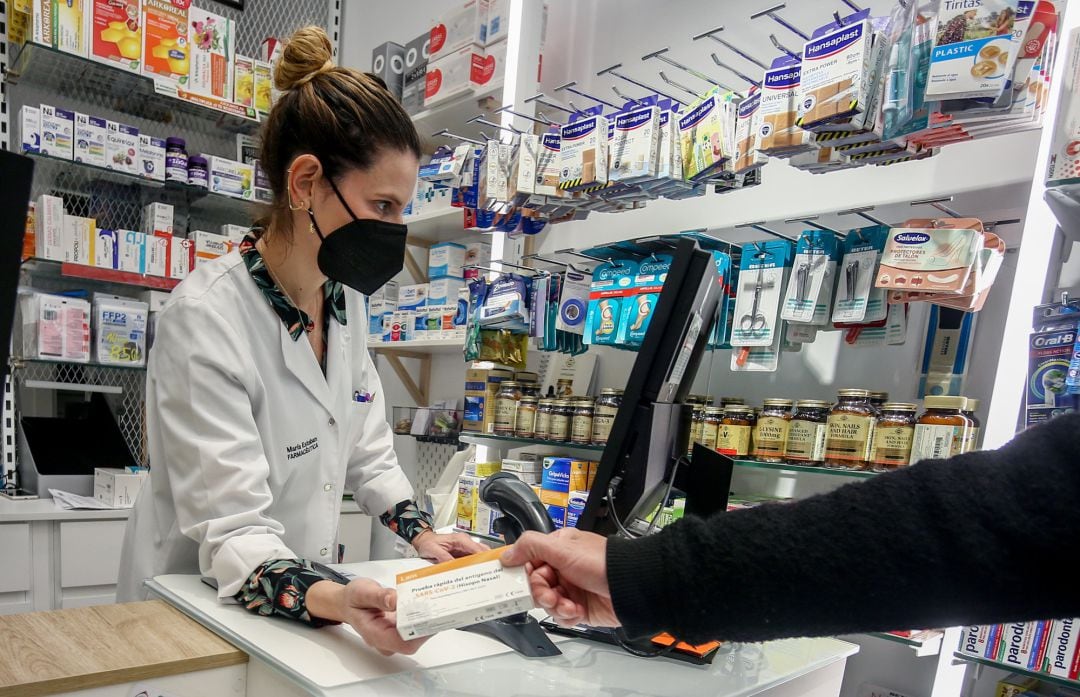 La farmacéutica de la Farmacia Lavapiés recoge un test de antígenos