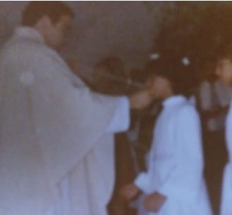 Foto del sacerdote D.A.M.M, a los 27 años, administrando la primera comunión a su víctima, de 9 años, tras meses de abusos sexuales al término de la catequesis de los sábados por la tarde, preparatoria de esta celebración.