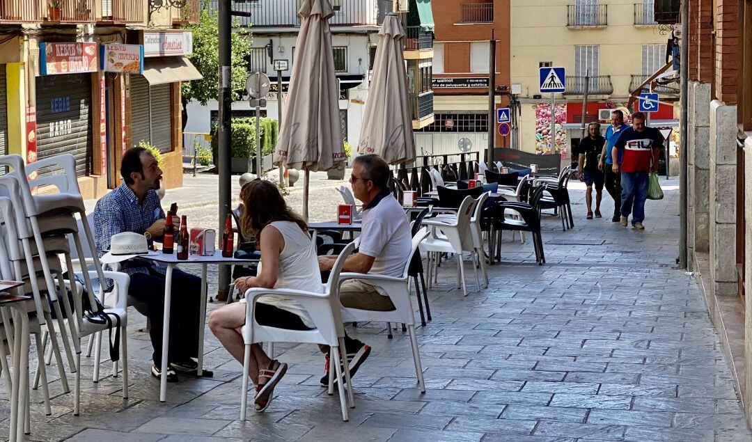 Tres personas sentadas en la terraza de un bar de la capital.