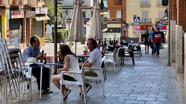 Tres personas sentadas en la terraza de un bar de la capital.