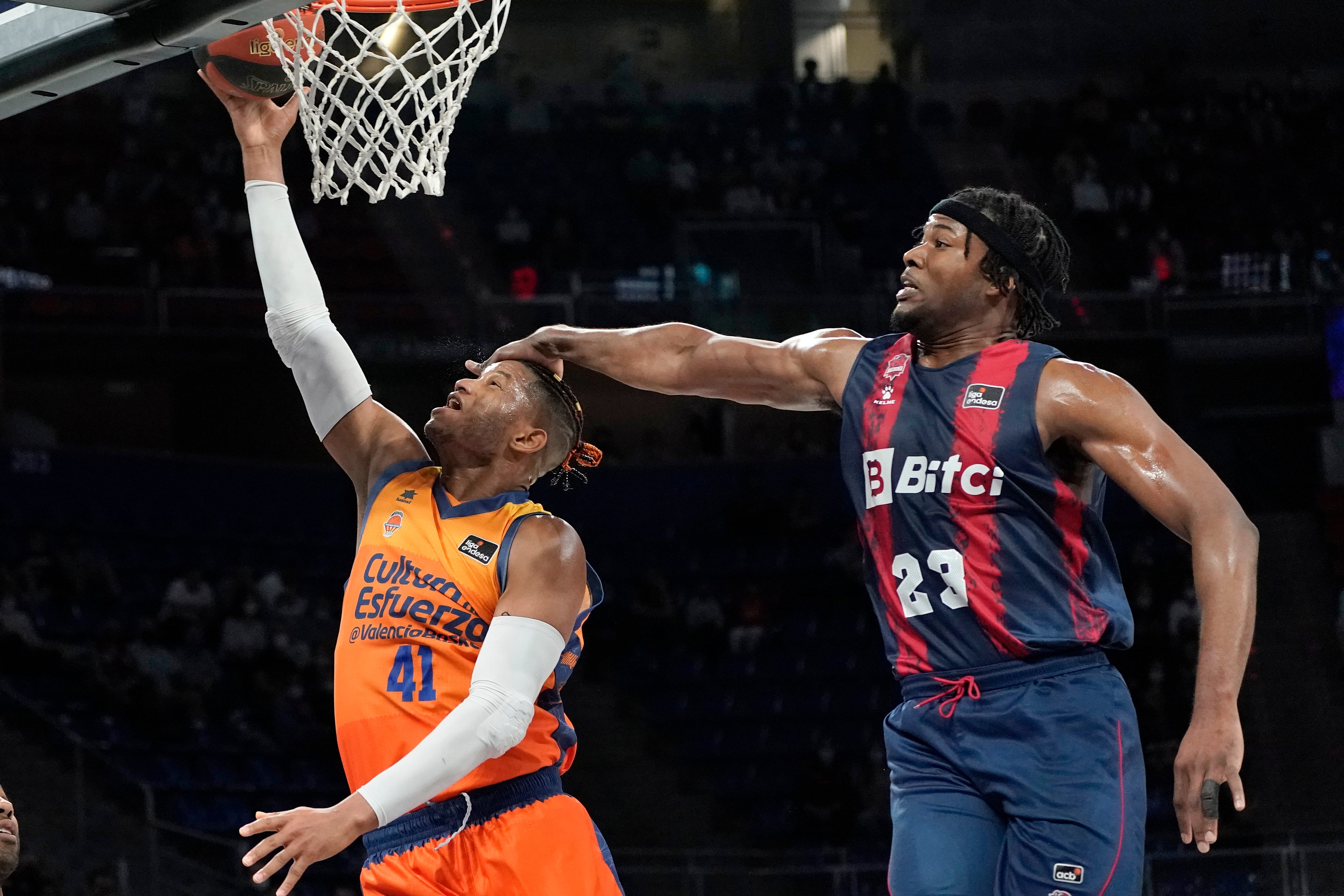 El ala-pívot cubano del Valencia Basket Jasiel Rivero (i) lanza a canasta defendido por Steven Enoch, del Baskonia, durante el partido de la jornada 29 de la Liga ACB. EFE/L. Rico