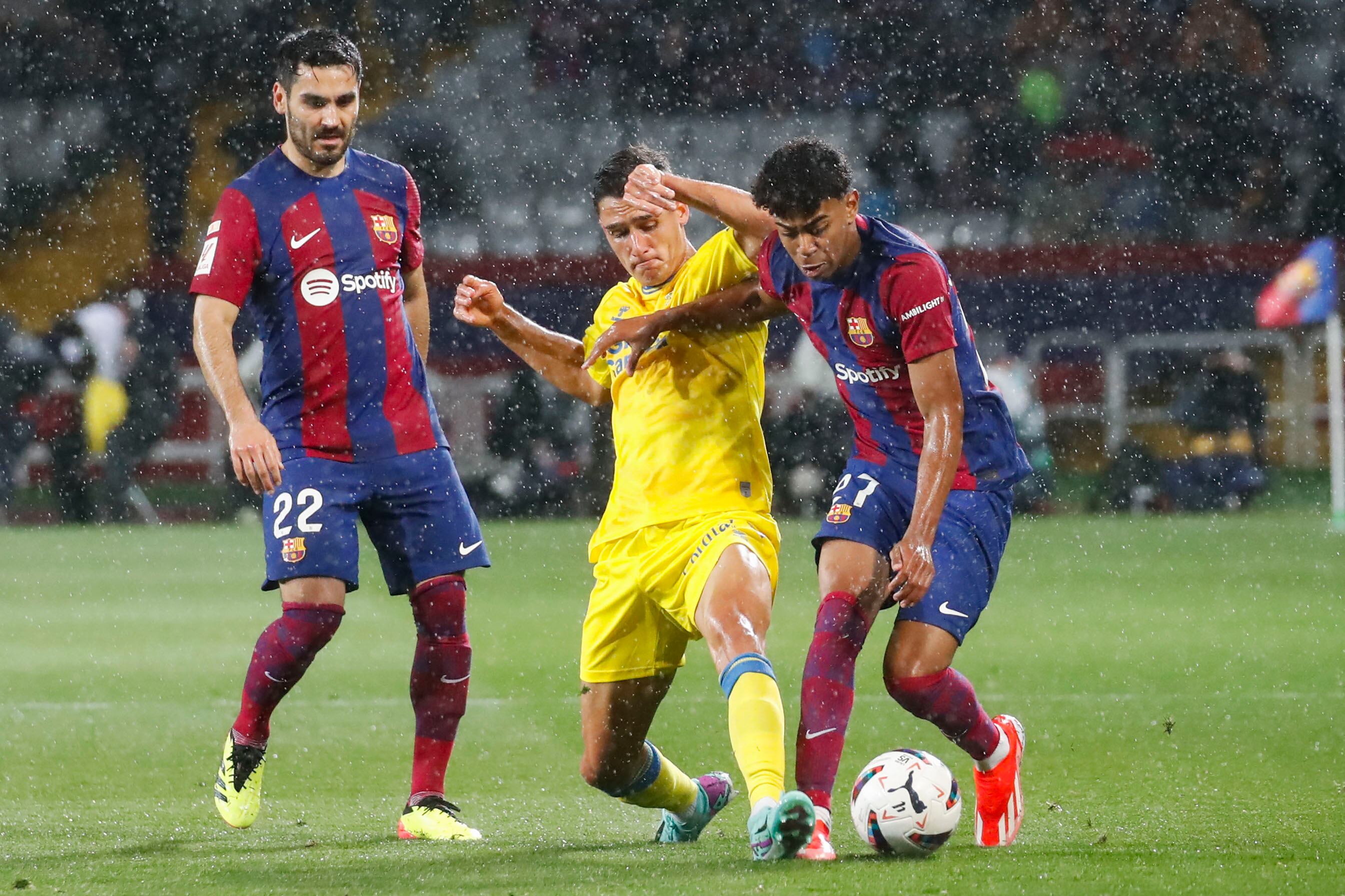 BARCELONA, 30/03/2024.- El delantero del FC Barcelona Lamine Yamal (d) lucha con Sergi Cardona (c), de la UD Las Palmas, durante el partido de la jornada 30 de LaLiga que FC Barcelona y UD Las Palmas disputan hoy sábado en el estadio olímpico Lluís Companys. EFE/ Marta Pérez
