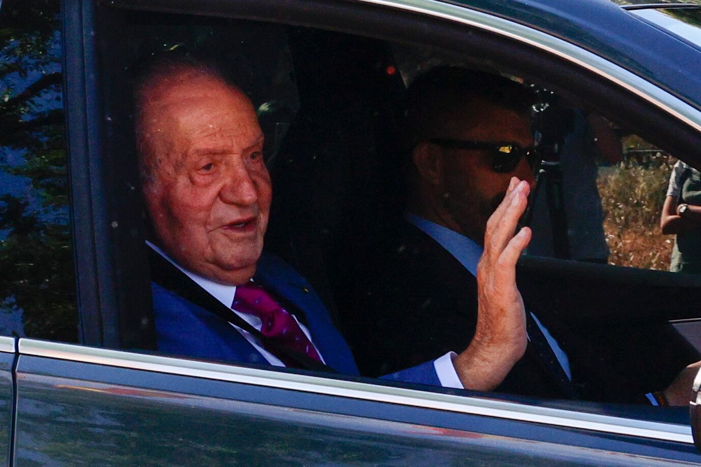 El rey Juan Carlos saluda a su llegada este lunes al Palacio de la Zarzuela de Madrid en su viaje de hace unos días