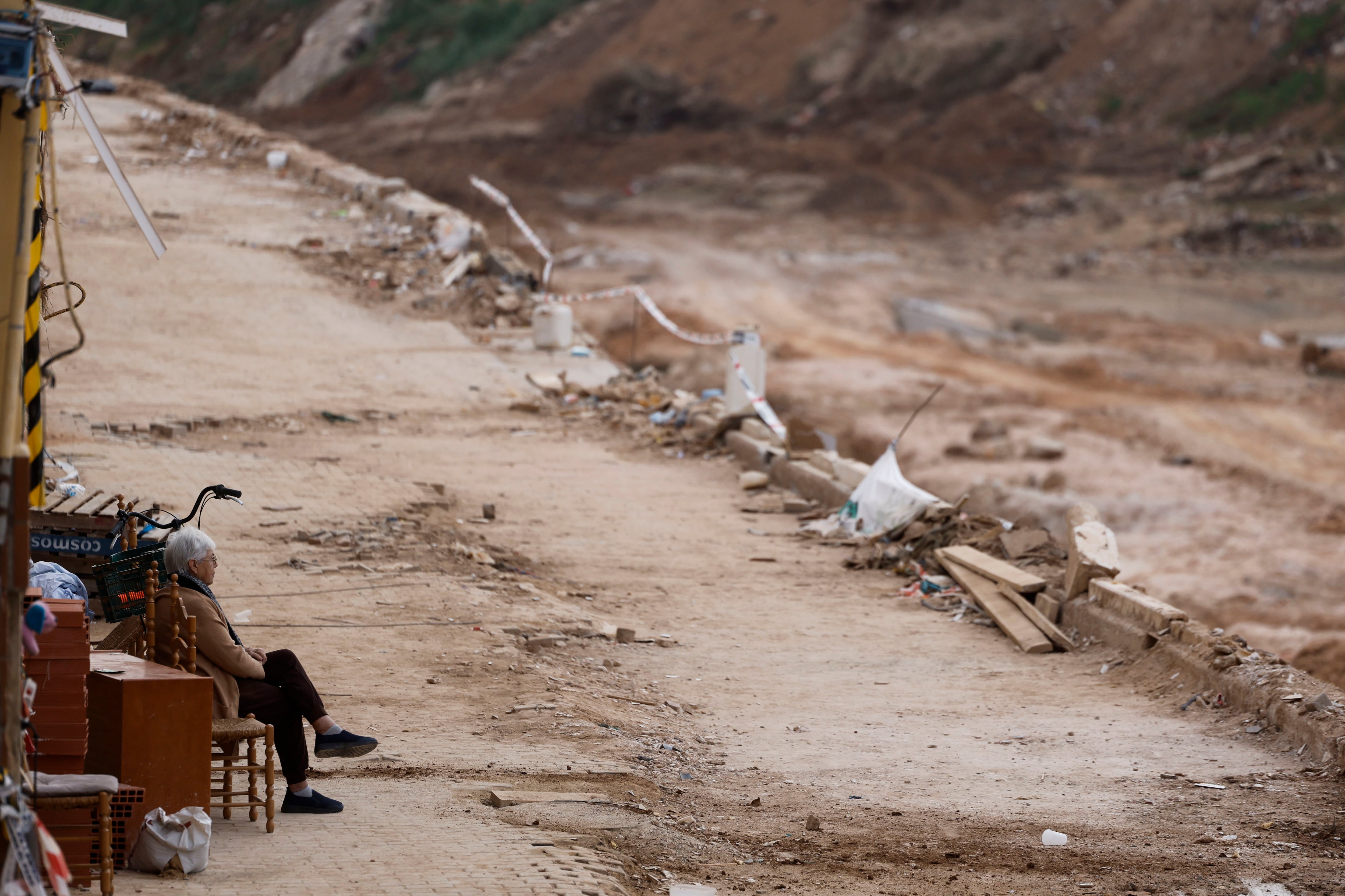 Una mujer descansa en una silla frente al barranco del Poyo en la localidad de Pincanya, en diciembre de 2024.