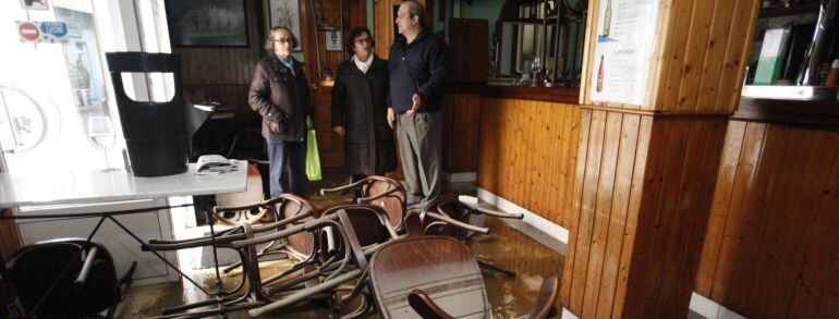 Unos vecinos de Sada (A Coruña) muestran el estado en el que ha quedado uno de los negocios tras las inundaciones 