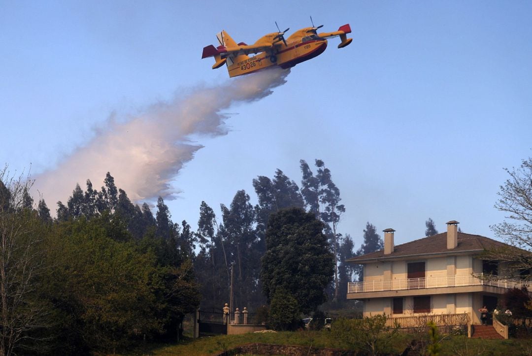 Un hidroavión arroja agua sobre el incendio en la localidad coruñesa de Rianxo, este virulento incendio forestal registrado en los municipios de Dodro y Rianxo, ambos en la provincia de A Coruña, ha arrasado ya 750 hectáreas, según las últimas estimaciones.