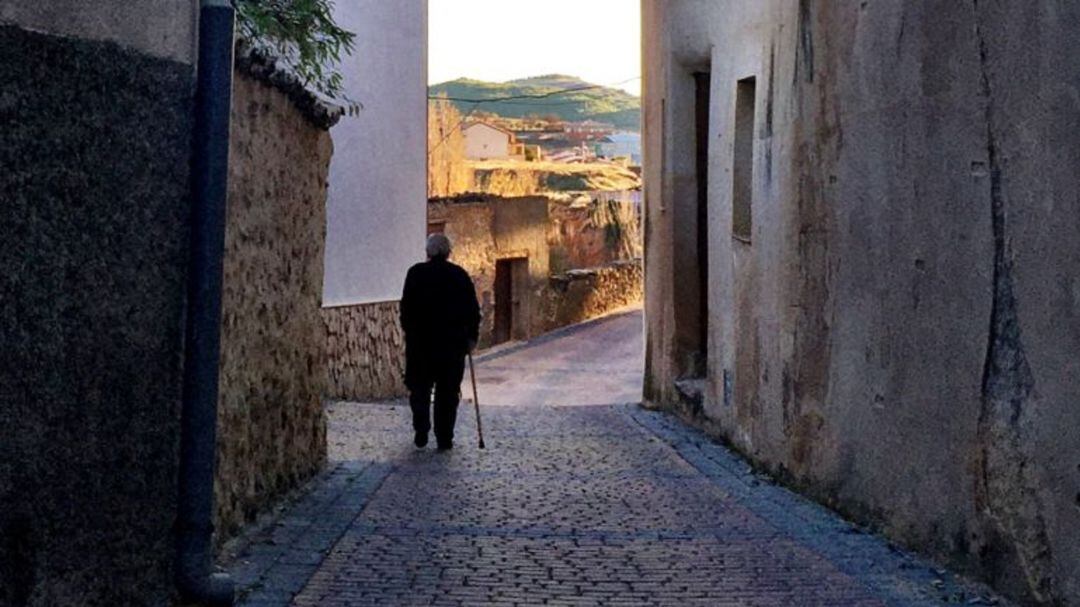 Una persona mayor camina por las calles de una localidad.