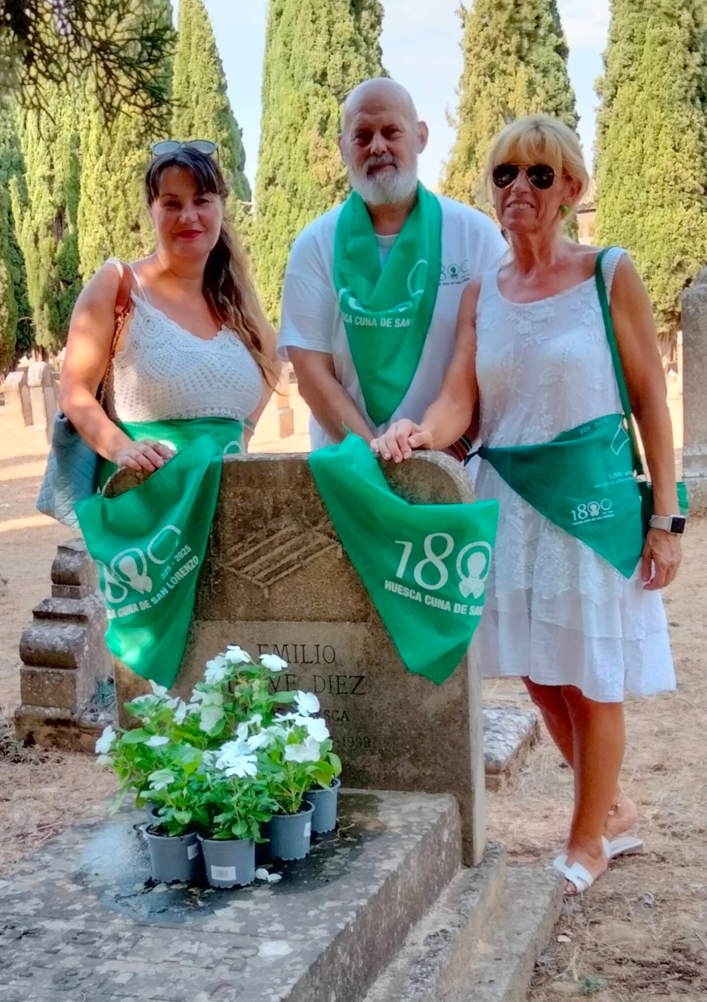 Anavi Luna, vocal de la Asociación Huesca Cuna de San Lorenzo, Javier Monsón, presidente, y Mª Cristina Vicén, vocal, en la tumba de Emilio Miravé