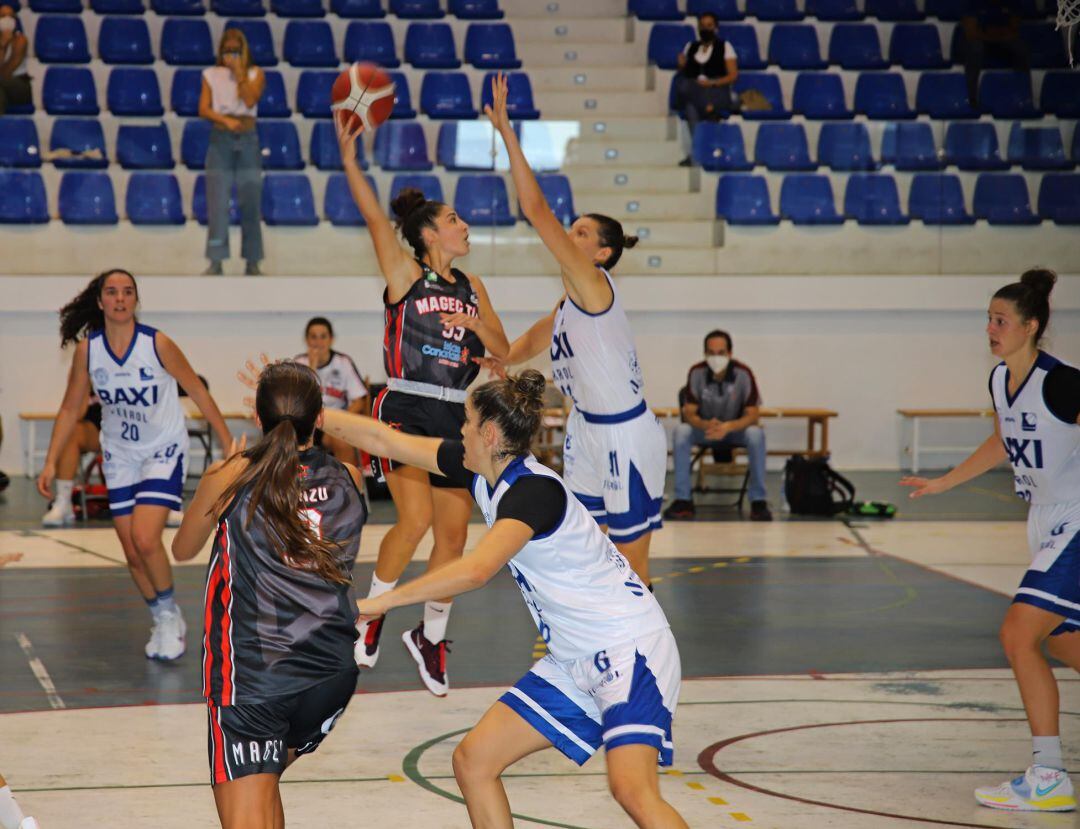 Jugadoras del Baxi Ferrol intentan taponar un lanzamiento del Magec Tías contra la Violencia de Género.