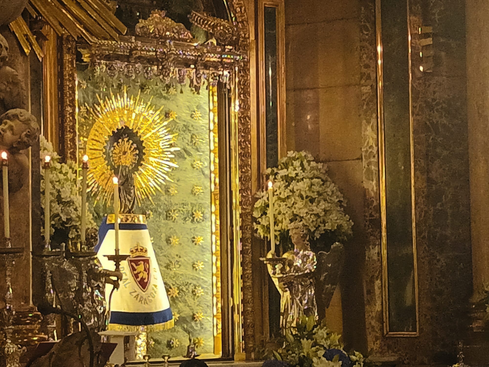 La Virgen del Pilar con un manto del Real Zaragoza puesto para la ofrenda de flores de inicio de temporada