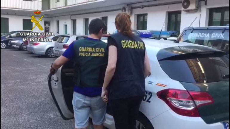 El detenido es introducido en el coche por agentes de la Guardia Civil