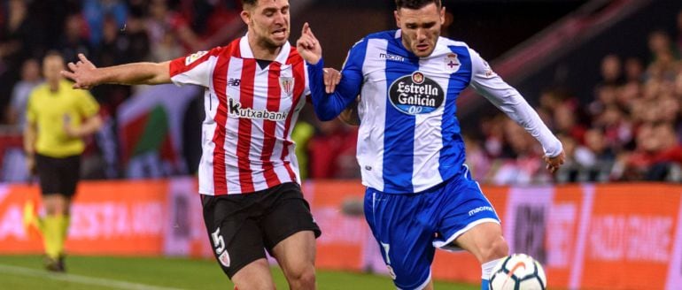 El delantero del Deportivo Lucas Pérez conduce el balón ante el acoso del defensa del Athletic de Bilbao Yeray Álvarez