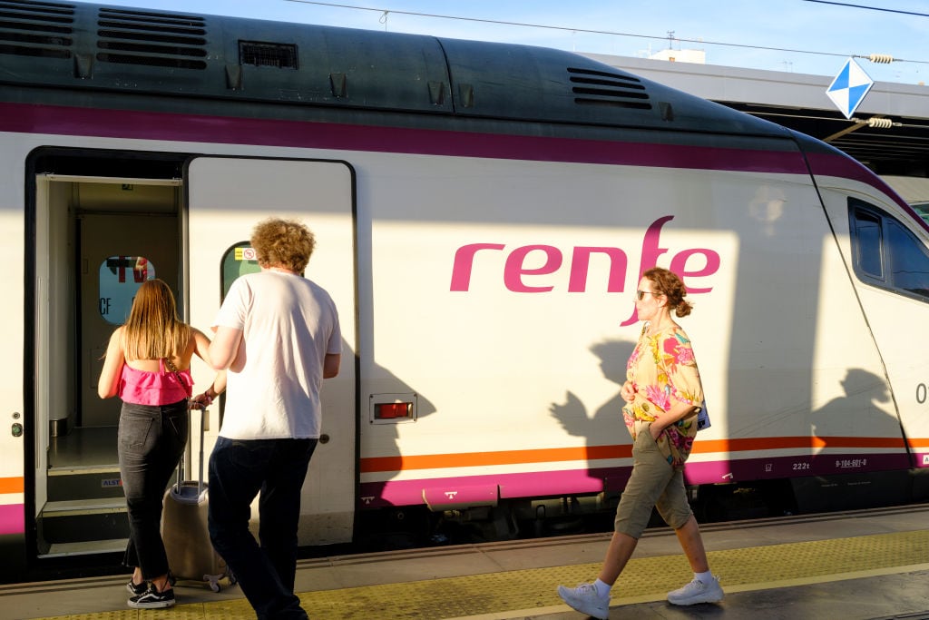 Viajeros de Renfe se suben a un tren.