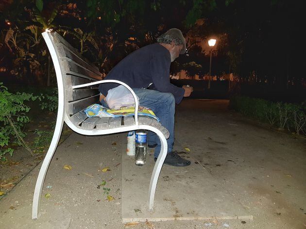 Hafid se prepara para dormir en un banco del Paseo del Parque