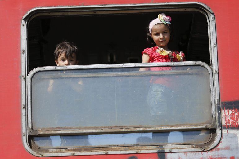 Niños refugaidos suben a un tren tras cruzar la frontera entre Macedonia y Grecia 