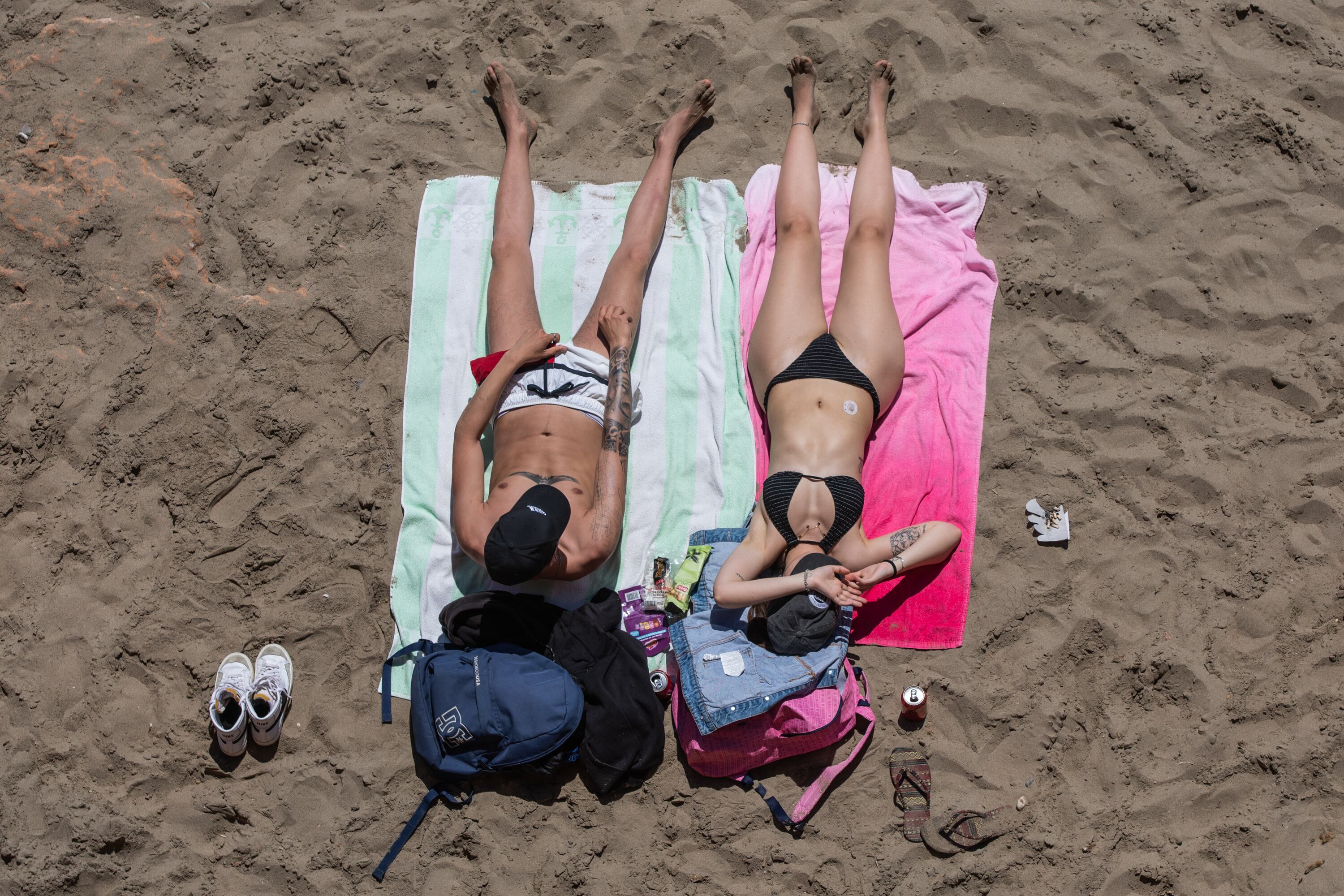 Dos turistas toman el sol en la playa es Bol Nou de Ibiza.