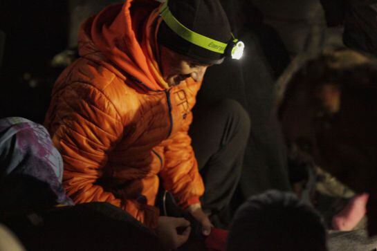 Joaquín Higueras ata los cordones del zapato de uno de los niños recien llegados a Lesbos