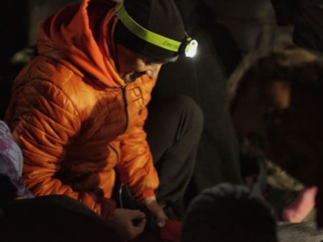 Joaquín Higueras ata los cordones del zapato de uno de los niños recien llegados a Lesbos