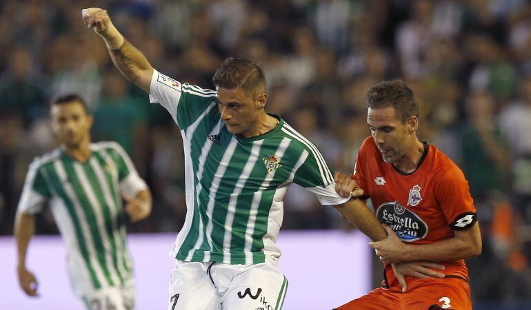 GRA513. SEVILLA, 24/09/2015.- El jugador del Real Betis Joaquín (i) es agarrado por Fernando Navarro, del Deportivo de La Coruña, durante el partido de Liga en Primera División que disputan esta noche en el estadio Benito Villamarín, en Sevilla. EFE/Julio Muñoz