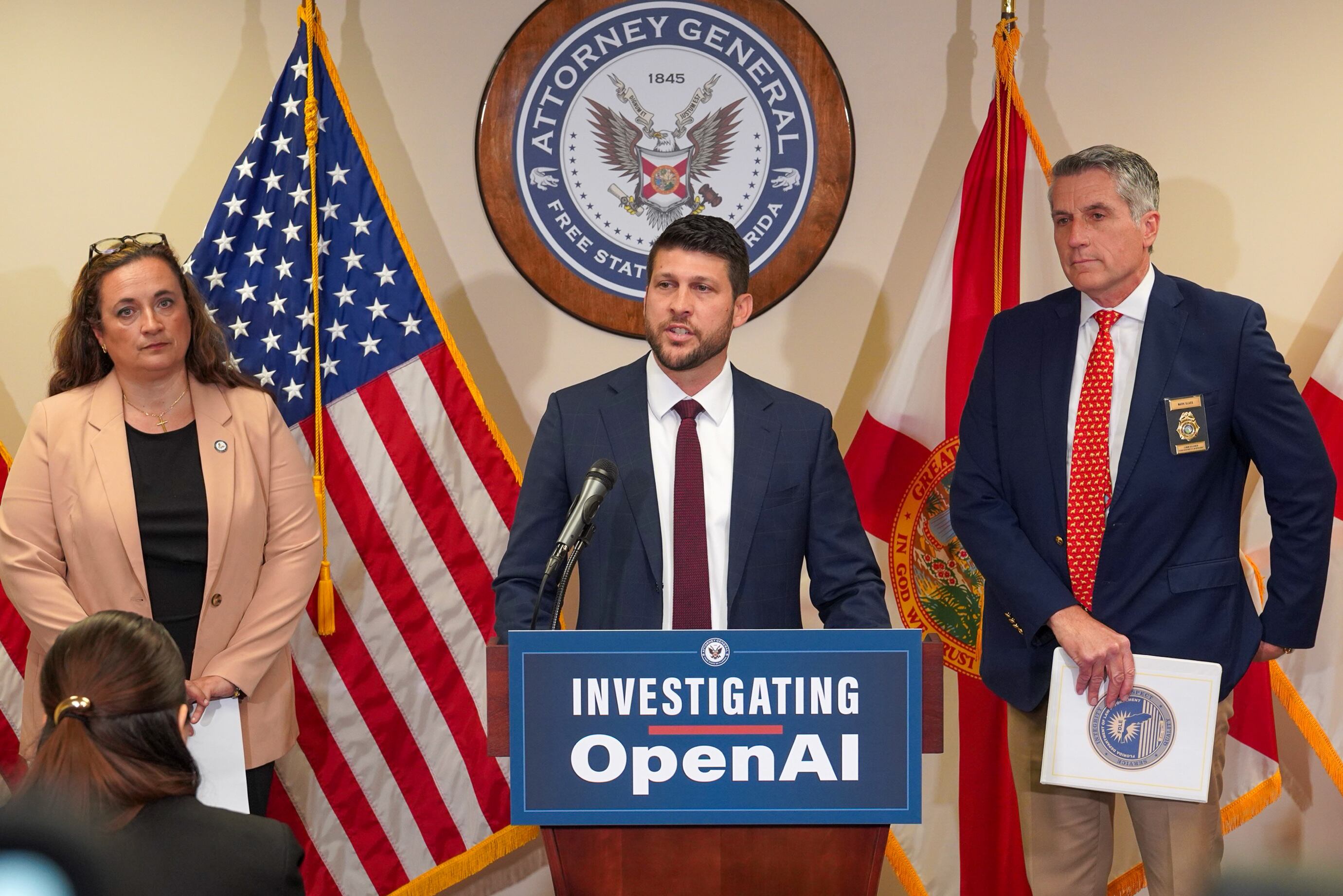 Fotografía cedida por la Oficina del Fiscal General de Florida donde aparece James Uthmeier (c) hablando durante una rueda de prensa sobre la investigación de Open AI este martes, en Tallahassee (Estados Unidos).