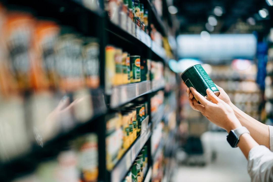 Una cliente observa un producto en las estanterías de un supermercado