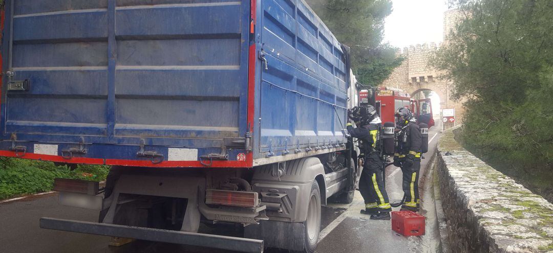 Bomberos actuando en el camión parado en la carretera del Castillo.