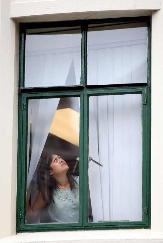 Una ciudadana mira por la ventana mientras escucha 'Todo por la radio'