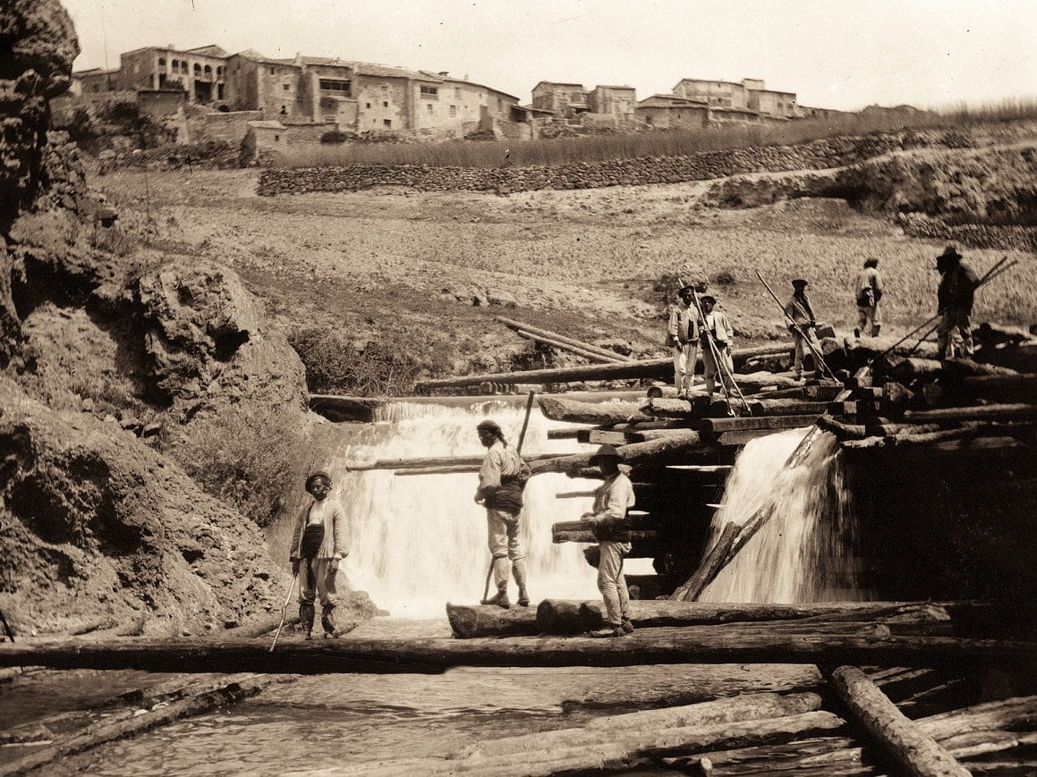 Maderada con los gancheros llevando los troncos por el río.