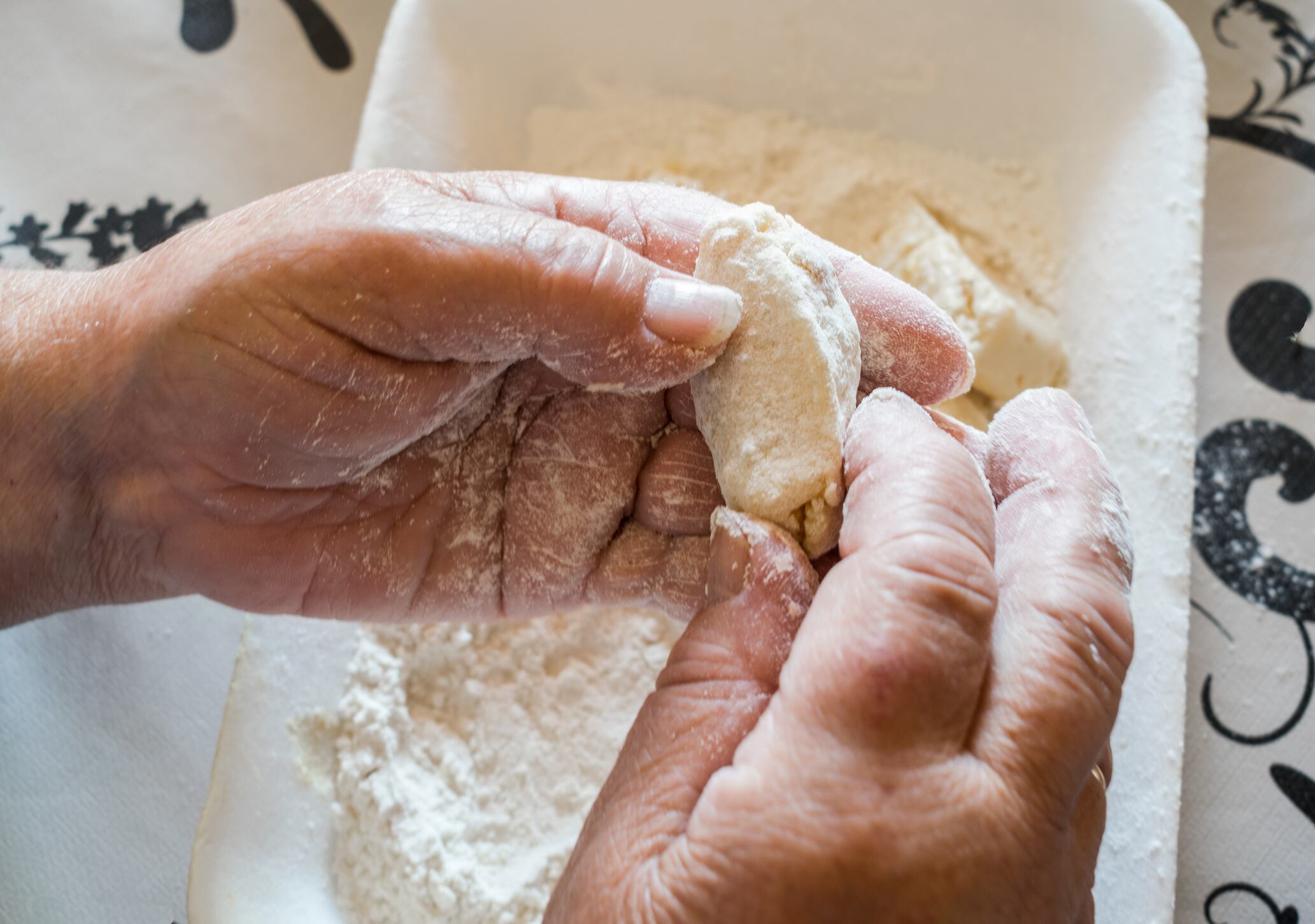 Una mujer preparando croquetas en casa.