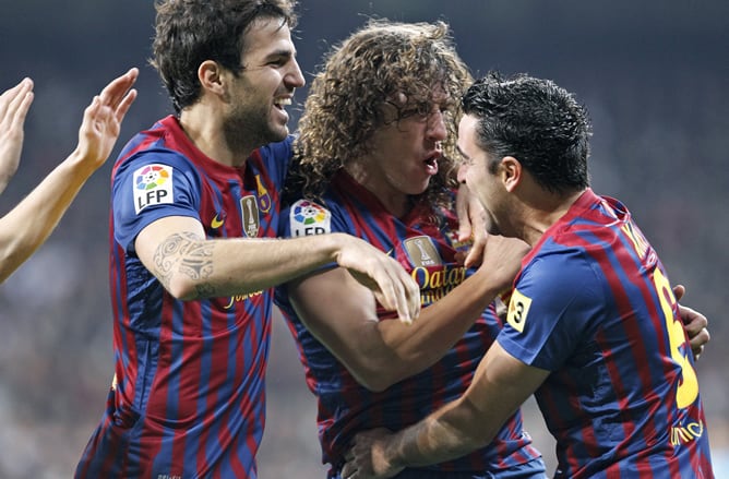 Los jugadores del F. C. Barcelona, Cesc Fábregas, Carles Puyol y Xavi Hernández, celebran el primer gol del equipo blaugrana, durante el encuentro correspondiente a la ida de los cuartos de final de la Copa del Rey, que les enfrenta esta noche al Real Mad