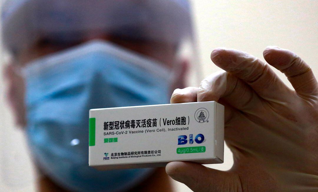 Una sanitaria soporta un envase de la vacuna de Sinopharm.