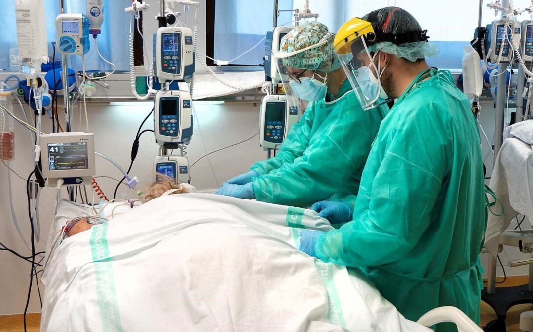 Dos profesionales sanitarios atienden a un enfermo en la UCI. 
