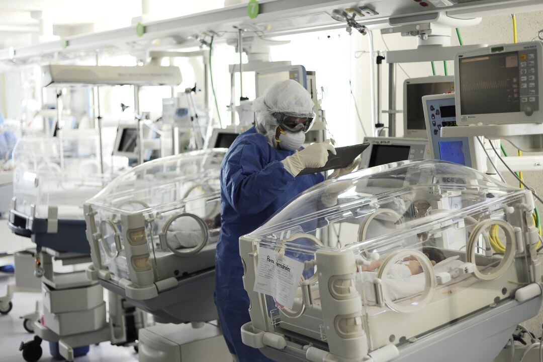 Una enfermera analiza el parte médico de un bebé positivo en COVID-19 en México
