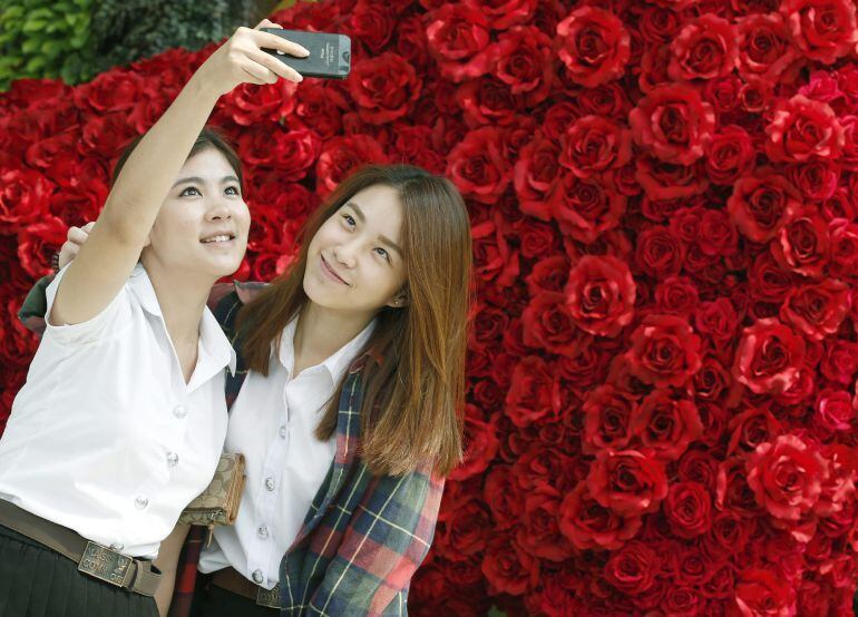 NAR08 BANGKOK (TAILANDIA) 11/02/2015.- Dos jóvenes posan para un selfi con un fondo de rosas en un centro comercial en Bangkok (Tailandia) hoy, miércoles 11 de febrero de 2015. EFE/Narong Sangnak