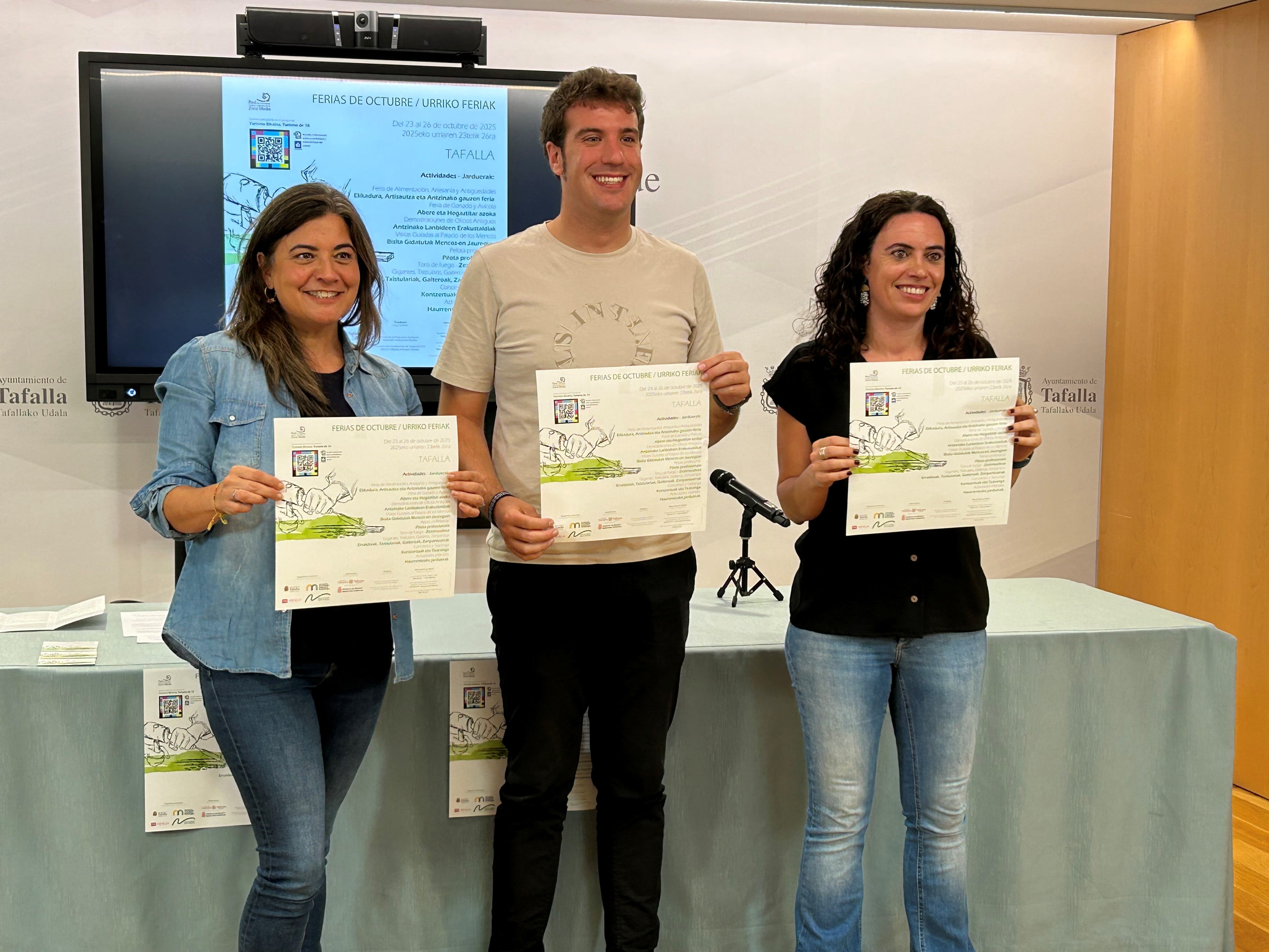 La técnica del CDZM, Maite Berrocal, el alcalde de Tafalla, Xabi Alcuaz y la concejala de ferias, Maitane Fernández, con el programa de las ferias de octubre