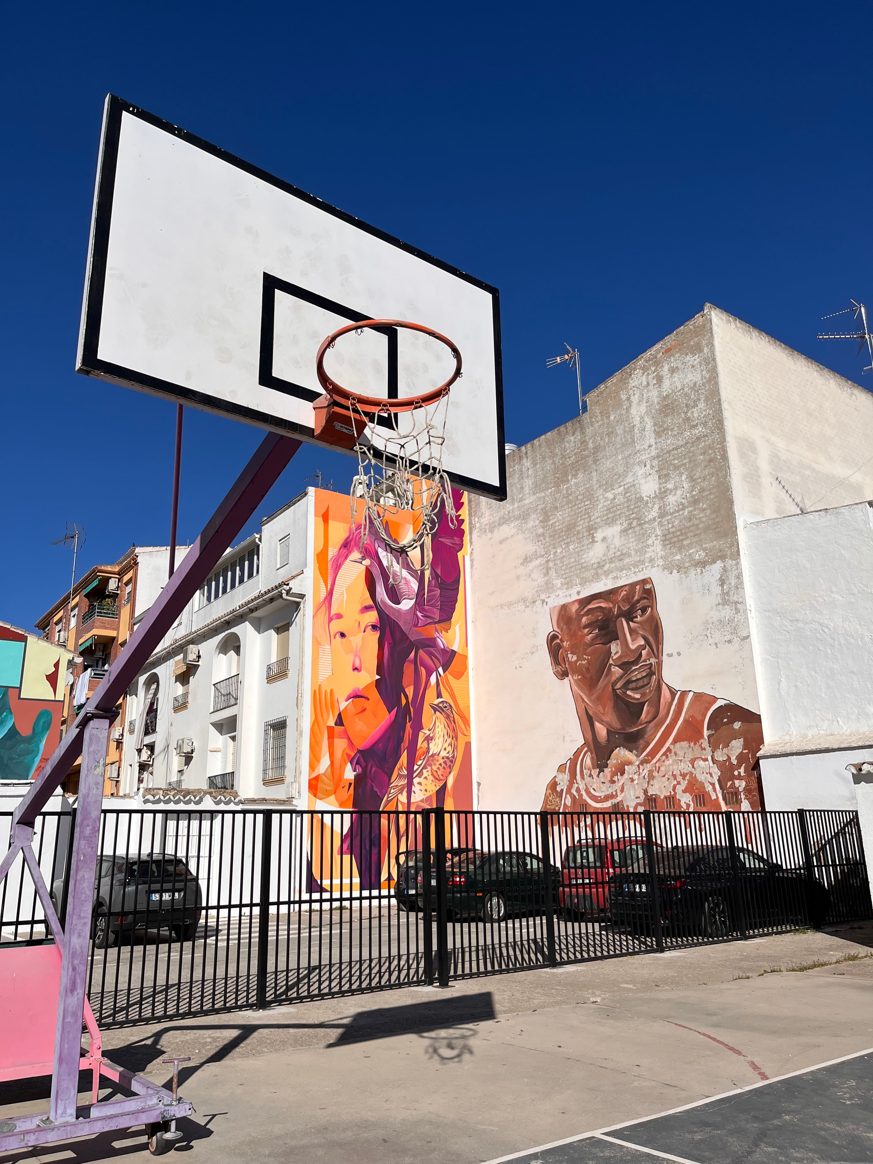 Dos de los grafitis de Sake frente a una cancha de Baena. A la derecha, un retrato de Michael Jordan. A la izquierda, un mural en colaboración con la artista argentina Fio Silva.