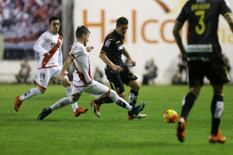 El defensa del Rayo Vallecano Roberto Román &quot;Tito&quot; (2i) pelea un balón con el centrocampista del Granada Roberto Medina &quot;Piti&quot; (2d) durante el partido de la undécima jornada de liga en Primera División que se disputa esta noche en el estadio de Vallecas. 