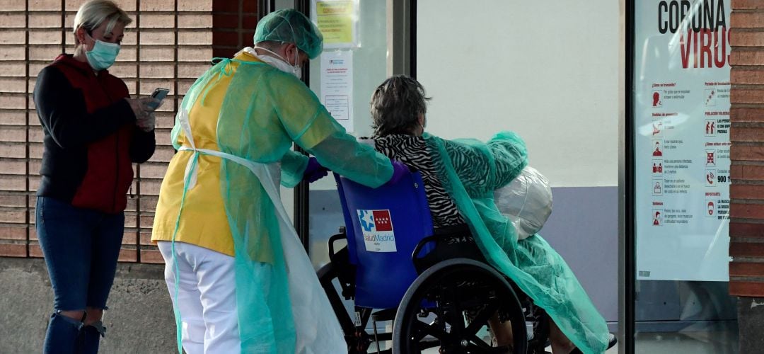 Un profesional ayuda a una paciente a acceder a las urgencias del Hospital Severo Ochoa de Leganés