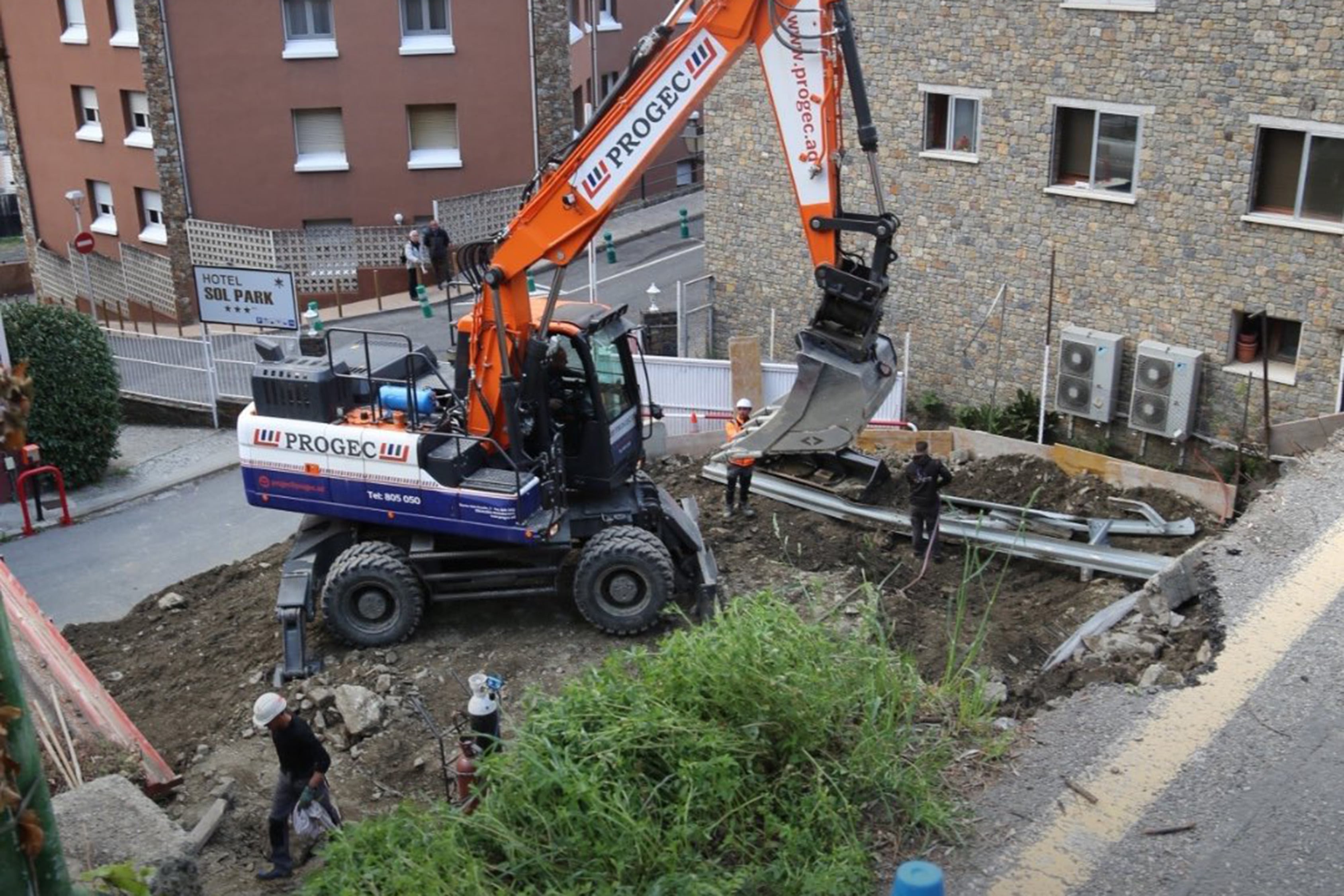 Uns operaris de la construcció treballant en un desmunt de Sant Julià.